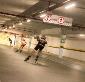 foto: André Francisco - Joinville - Vista das costas de três patinadores patinando velocidade dentro do estacionamento do Garten Shopping
