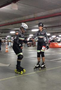 Foto Ricardo Müller - Duas patinadoras na linha de largada, uma é deficiente visual e segura a mão de sua guia, preparando-se para a corrida
